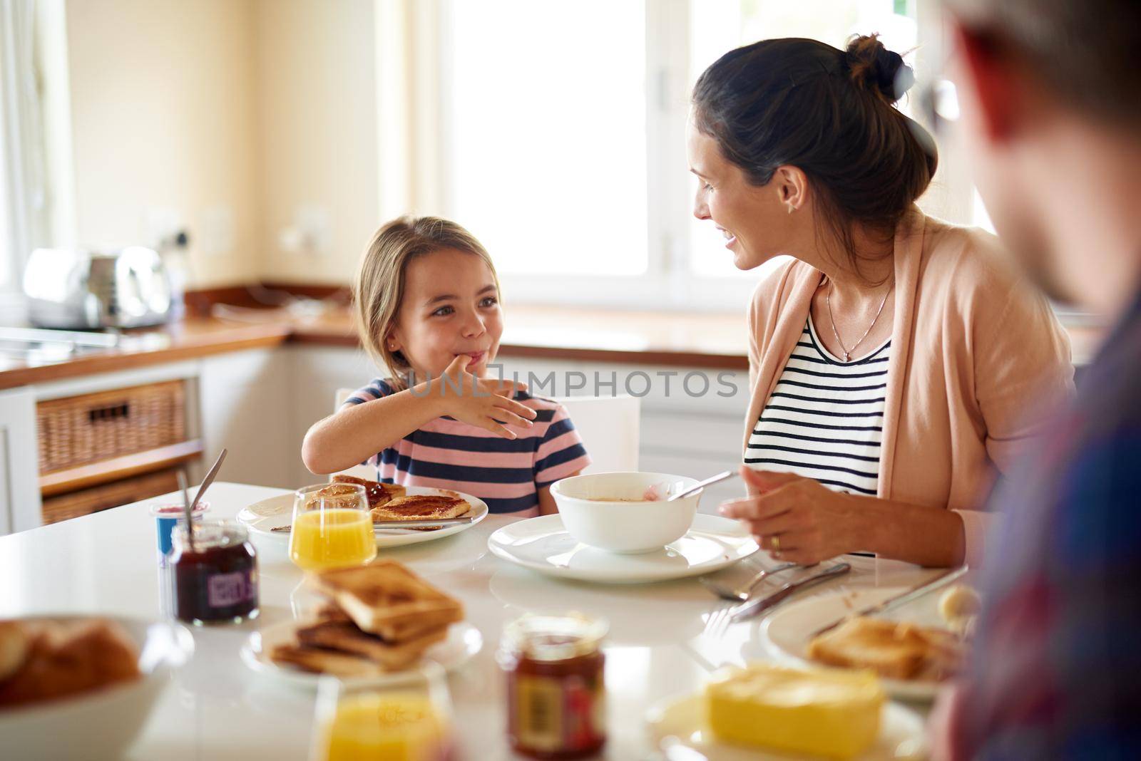 Having fun at the breakfast table. Shot of a family having breakfast together. by YuriArcurs