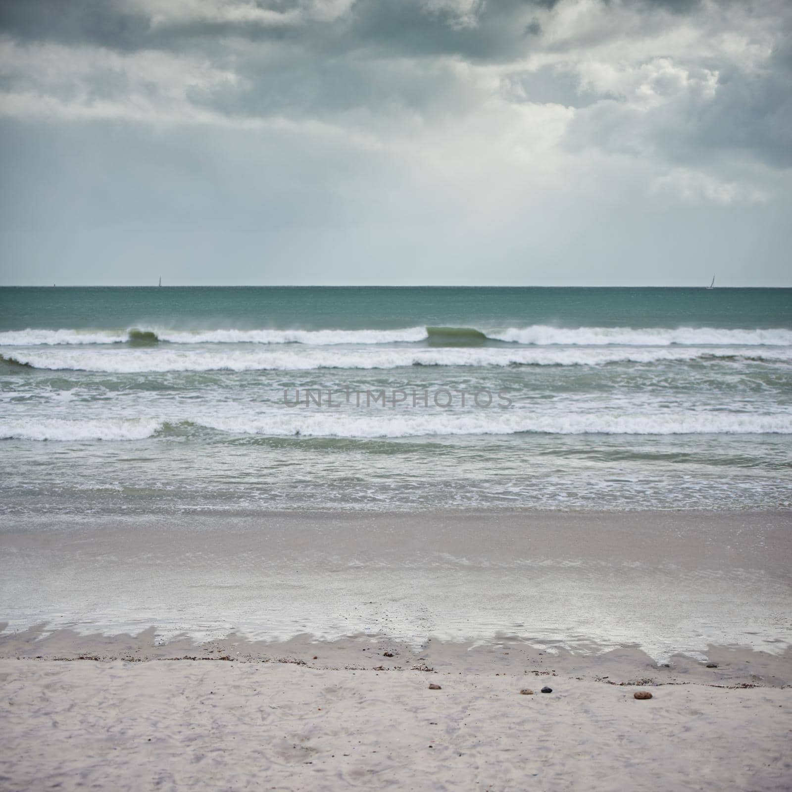 Landscape shot of a beach on a cloudy day.