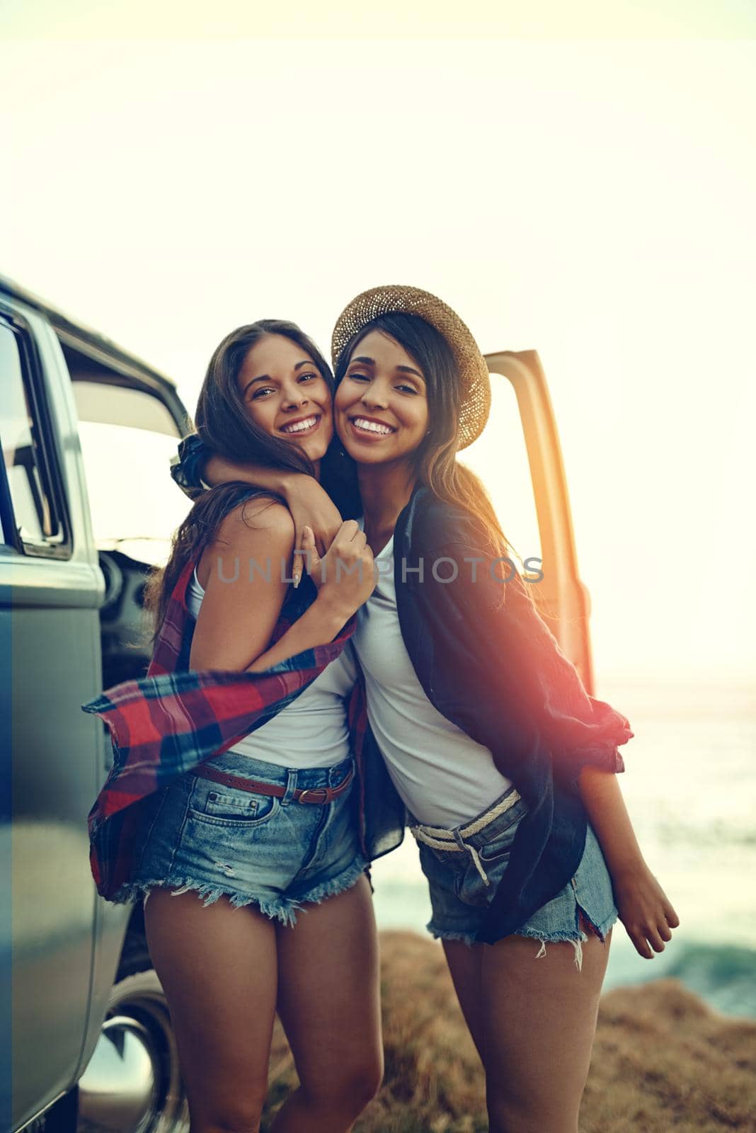 Everybody needs a road trip buddy and shes mine. Shot of two affectionate friends stopping at the beach during their roadtrip. by YuriArcurs