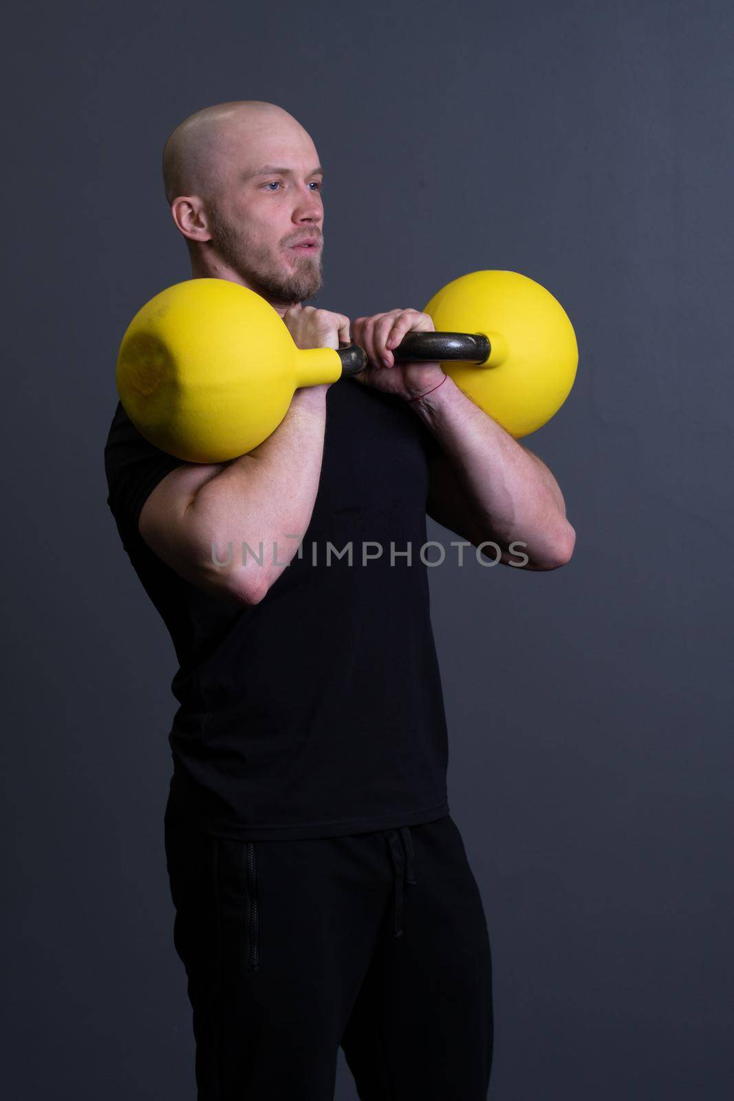 Guy with a yellow kettlebell gym anonymous young strength, in the afternoon fit lifestyle for picking and up weightlifting, southeast fitness. Guy down endurance, muscle hiit
