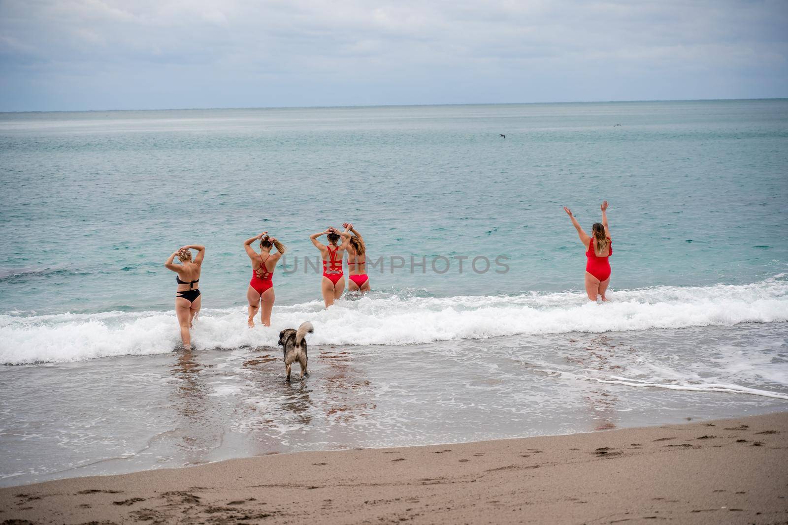 Big happy family or group of five friends is having fun against sunset beach. Beach holidays concept