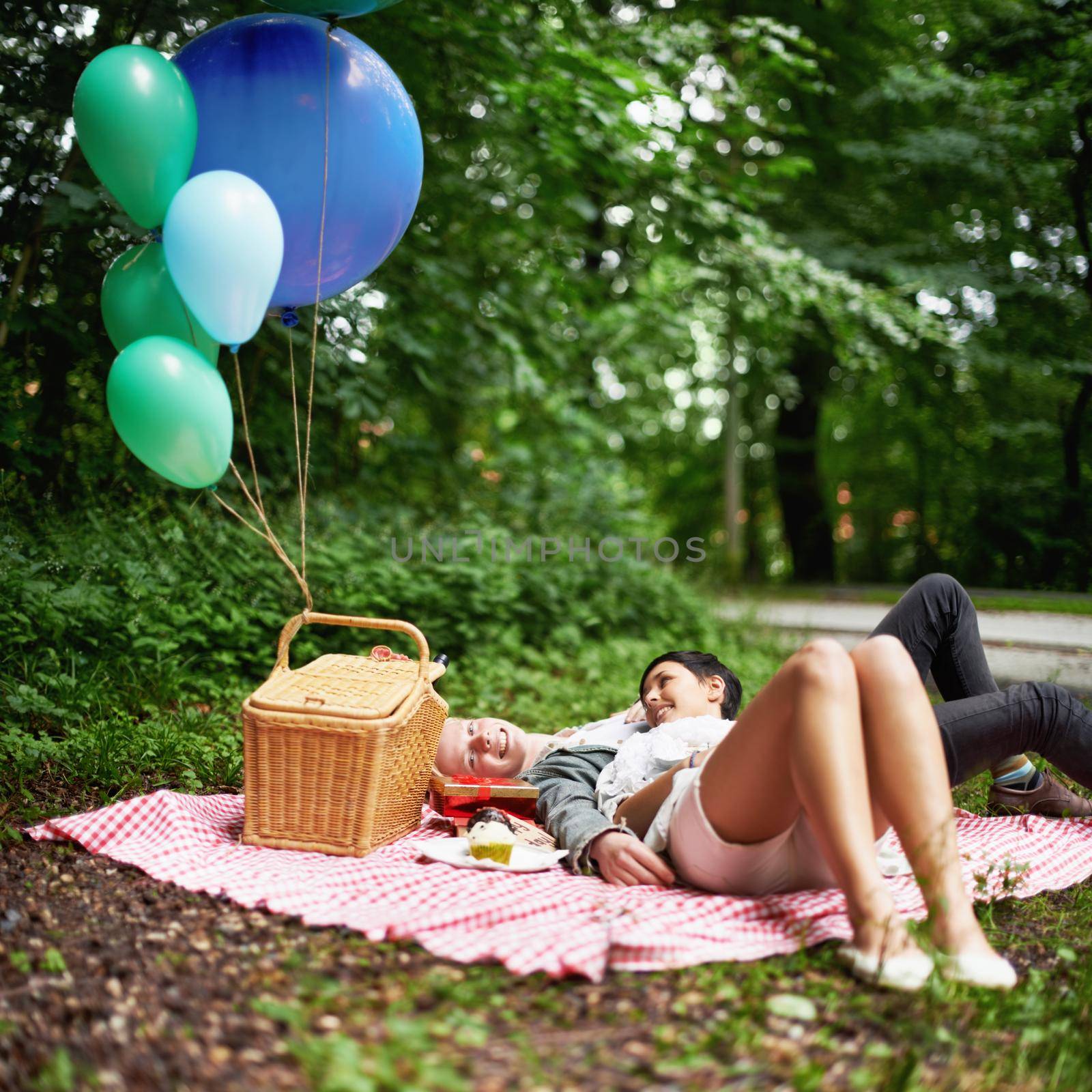 A young couple relaxing together while on a picnic in a forest.