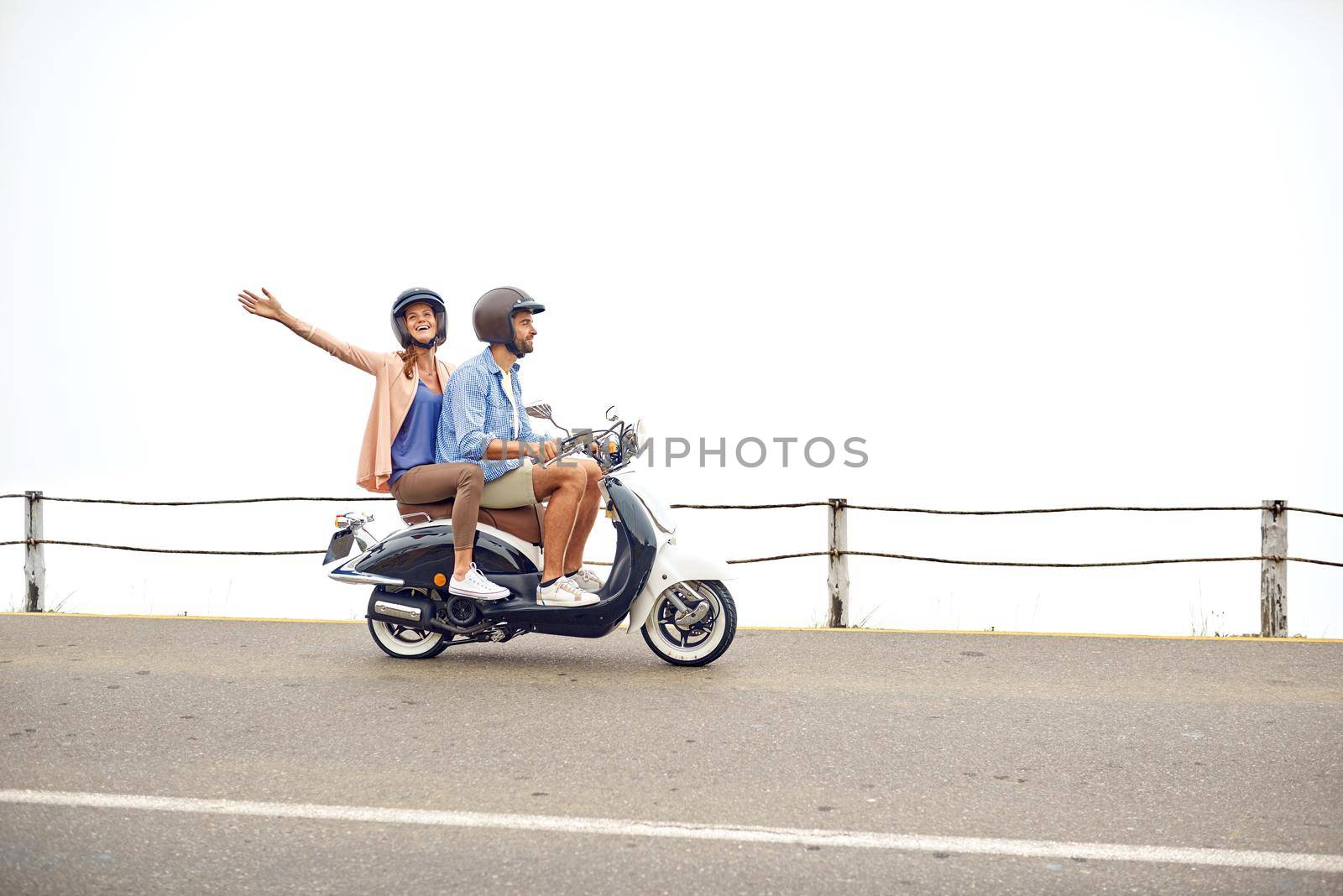 Having a good time on our road trip. Shot of an adventurous couple out for a ride on a motorbike. by YuriArcurs