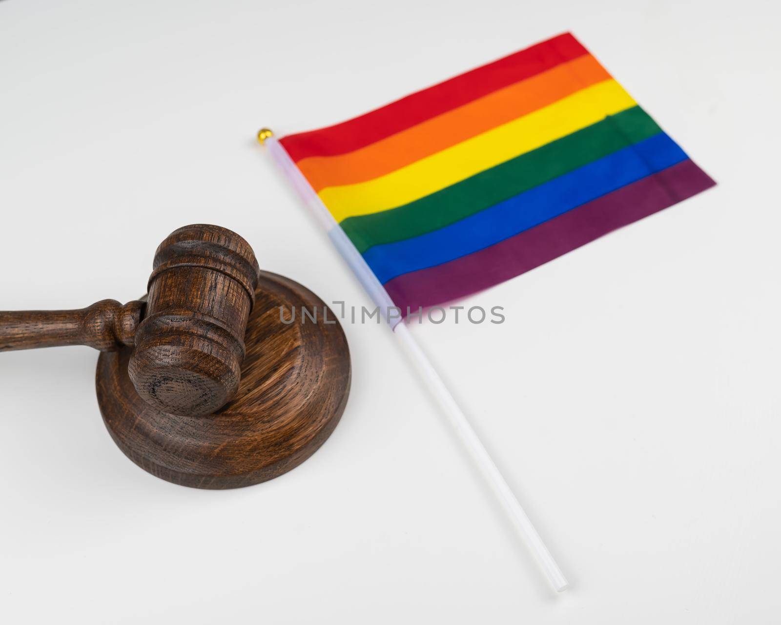 Judge gavel and hand lgbt flag isolated on white background