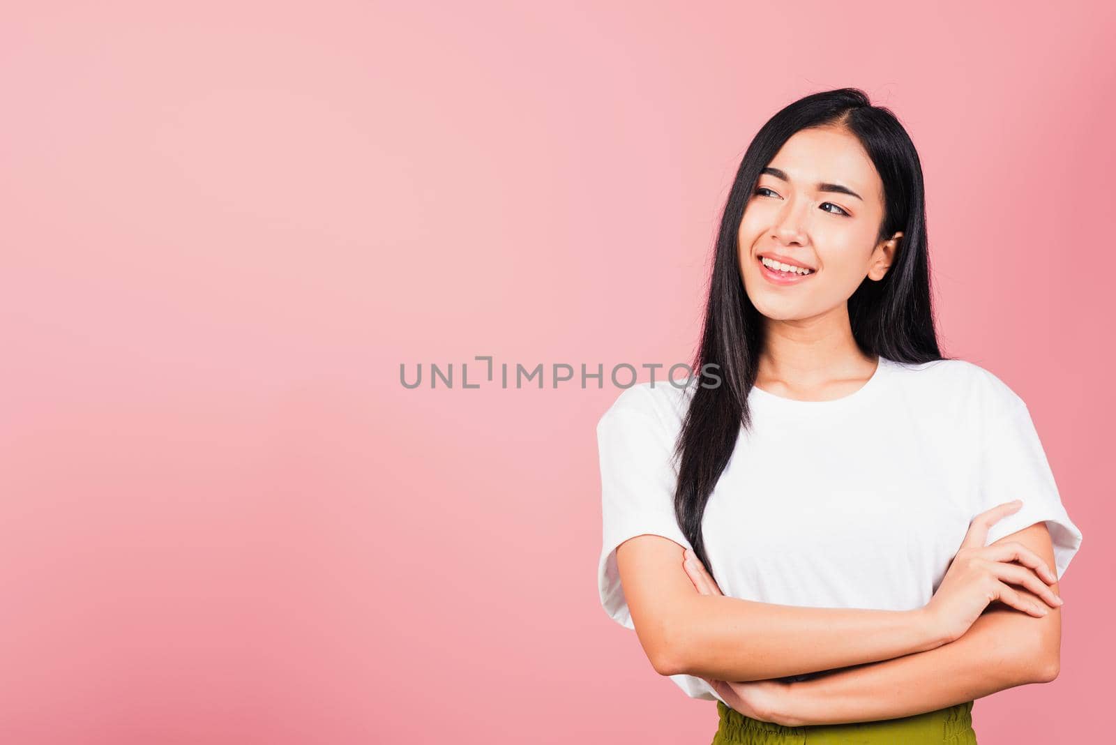 Asian happy portrait beautiful cute young woman standing her smile confidence with crossed arms isolated, studio shot on pink background and copy space, Thai female looking to side away