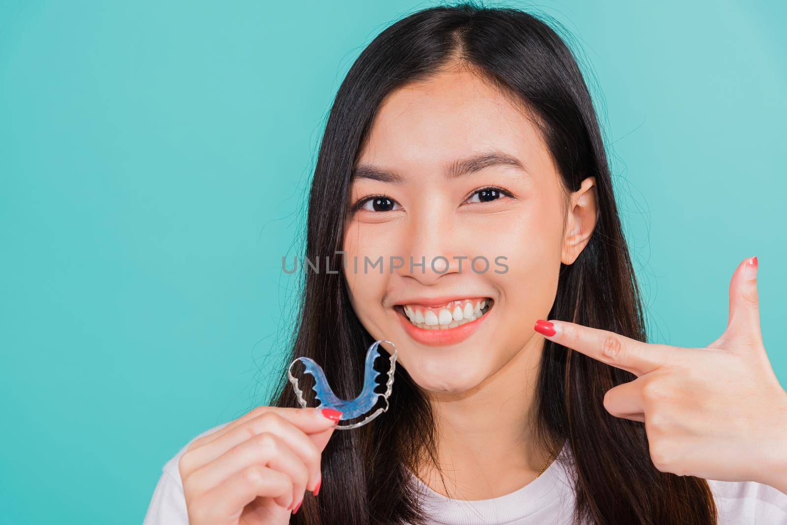 beautiful woman smiling pointing with finger silicone orthodontic retainers by Sorapop