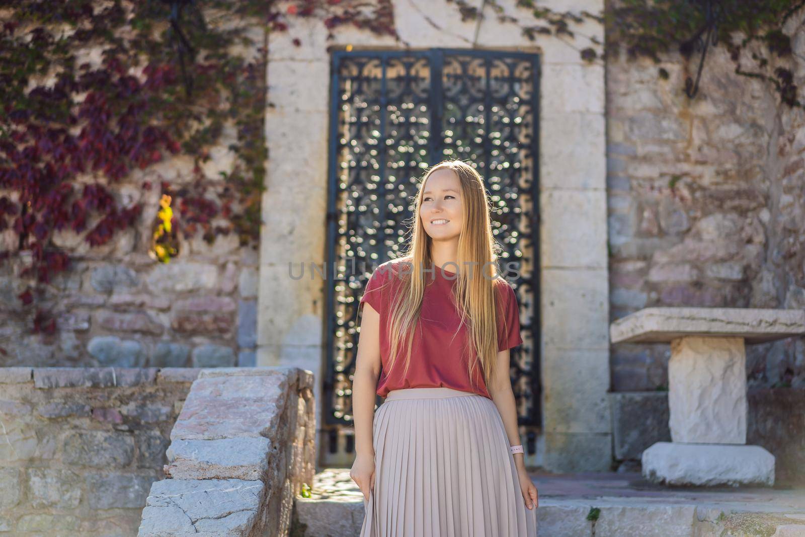 Woman tourist on background of beautiful view of the island of St. Stephen, Sveti Stefan on the Budva Riviera, Budva, Montenegro. Travel to Montenegro concept.