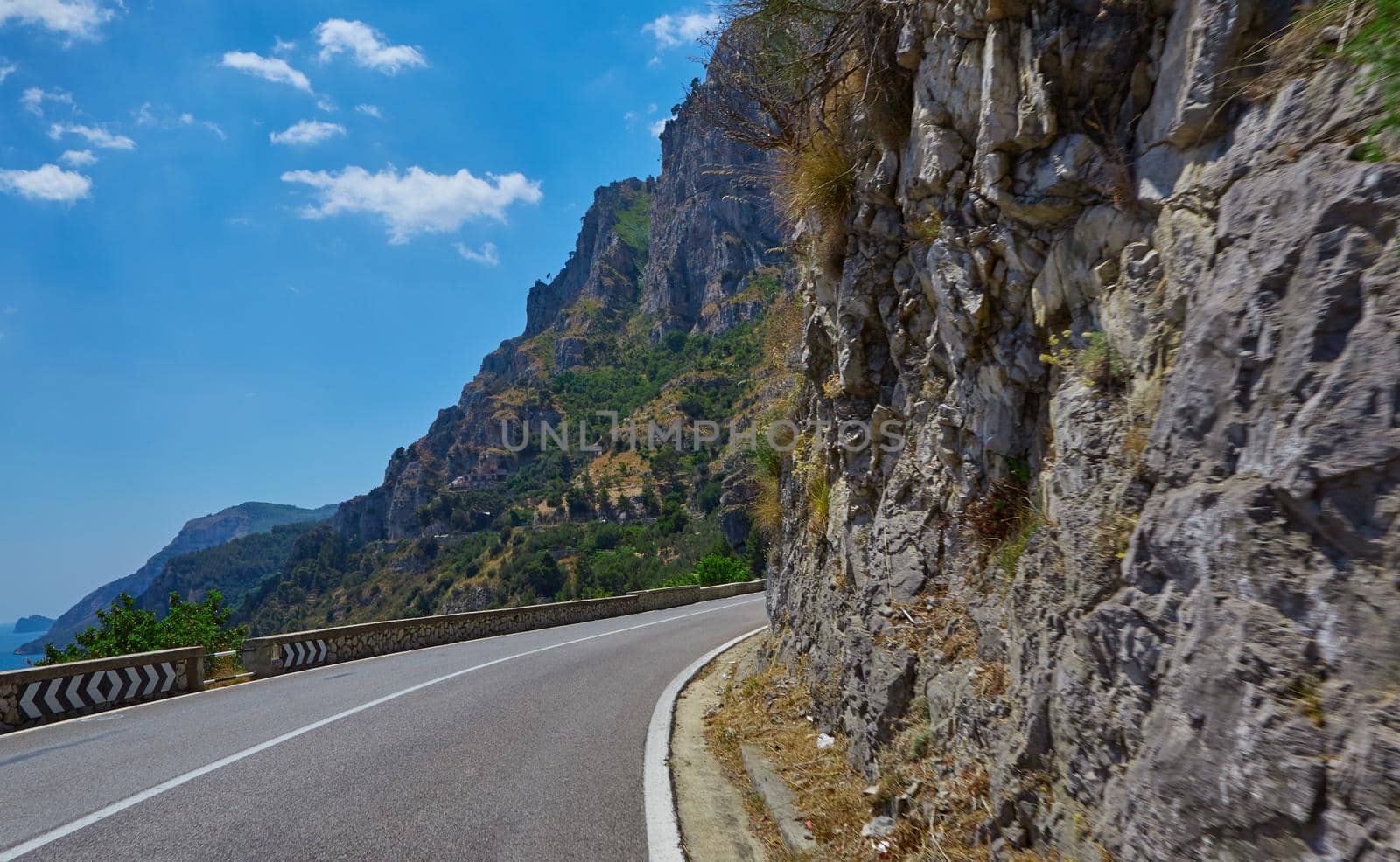 Asphalt road. Colorful landscape with beautiful mountain road with a perfect asphalt. High rocks, blue sky at sunrise in summer. Vintage toning. Travel background. Highway at mountains.