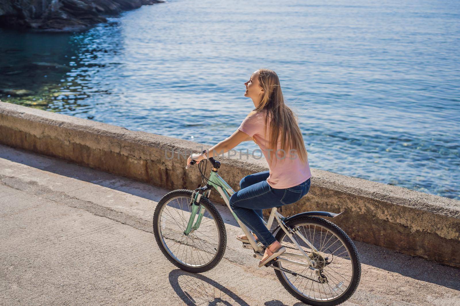 Woman tourist on a bicycle explores Budva in Montenegro. Cycling in Montenegro concept.