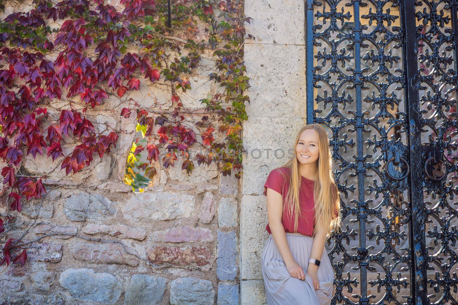 Woman tourist on background of beautiful view of the island of St. Stephen, Sveti Stefan on the Budva Riviera, Budva, Montenegro. Travel to Montenegro concept.