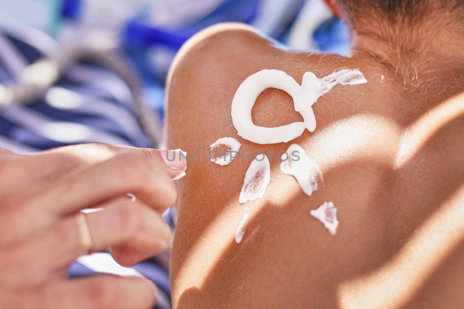 Woman apply protective sunscreen on the boy's shoulders skin by Lazy_Bear