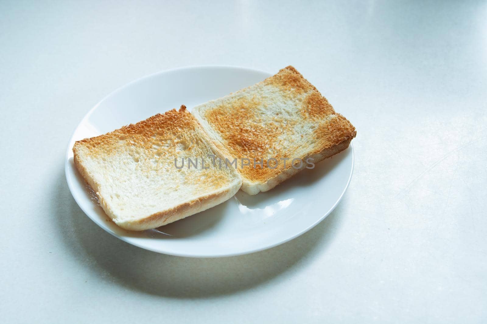 Two baked toasts lying on a plate by darekb22
