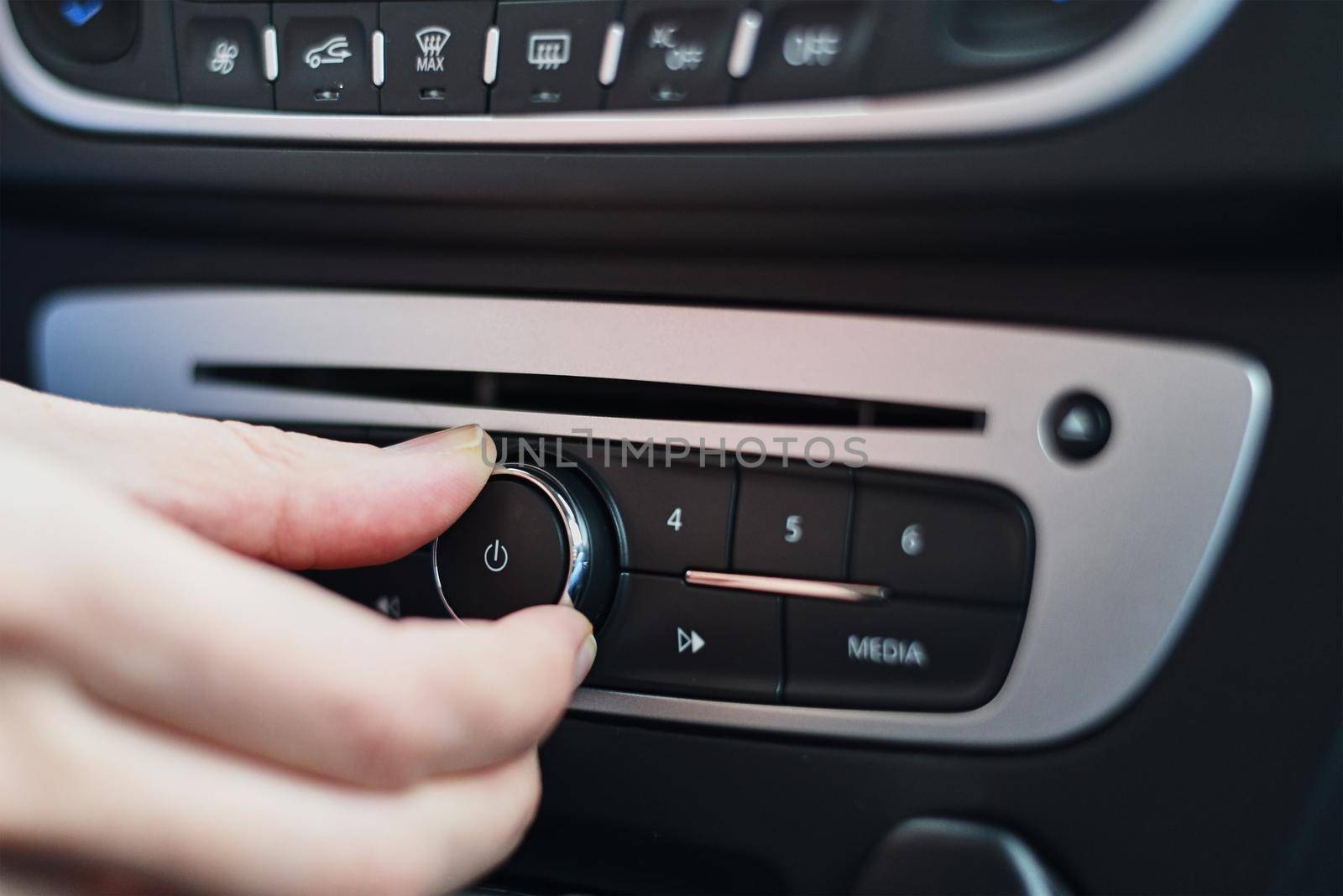 Hand press on button on car radio, close up
