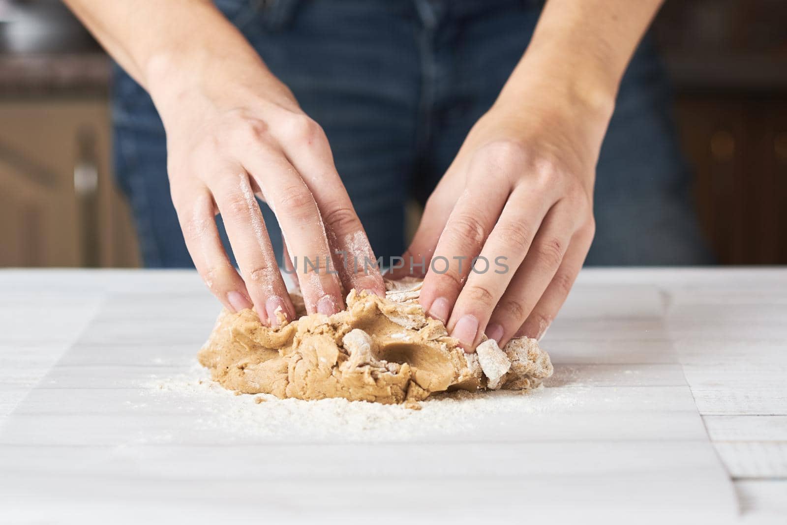 Woman kneads dough with hands in the kitchen by Lazy_Bear