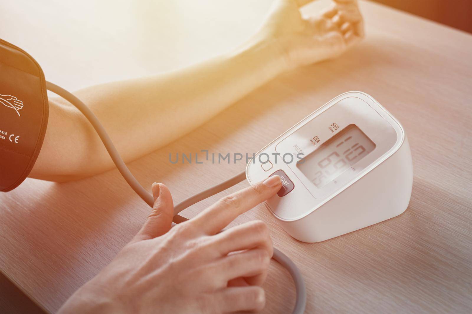 Woman measuring blood pressure with an electric digital tonometer. Healthcare and medicine concept by Lazy_Bear