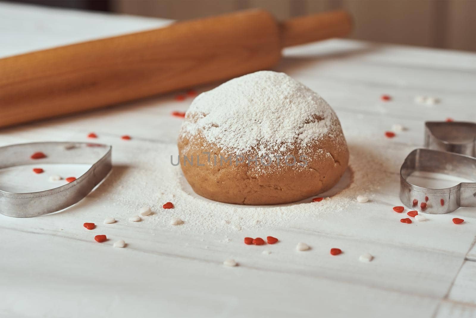 ball of raw dough sprinkled with flour on table