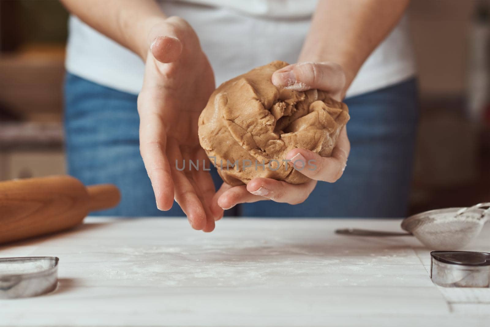 Woman kneads dough with hands in the kitchen by Lazy_Bear