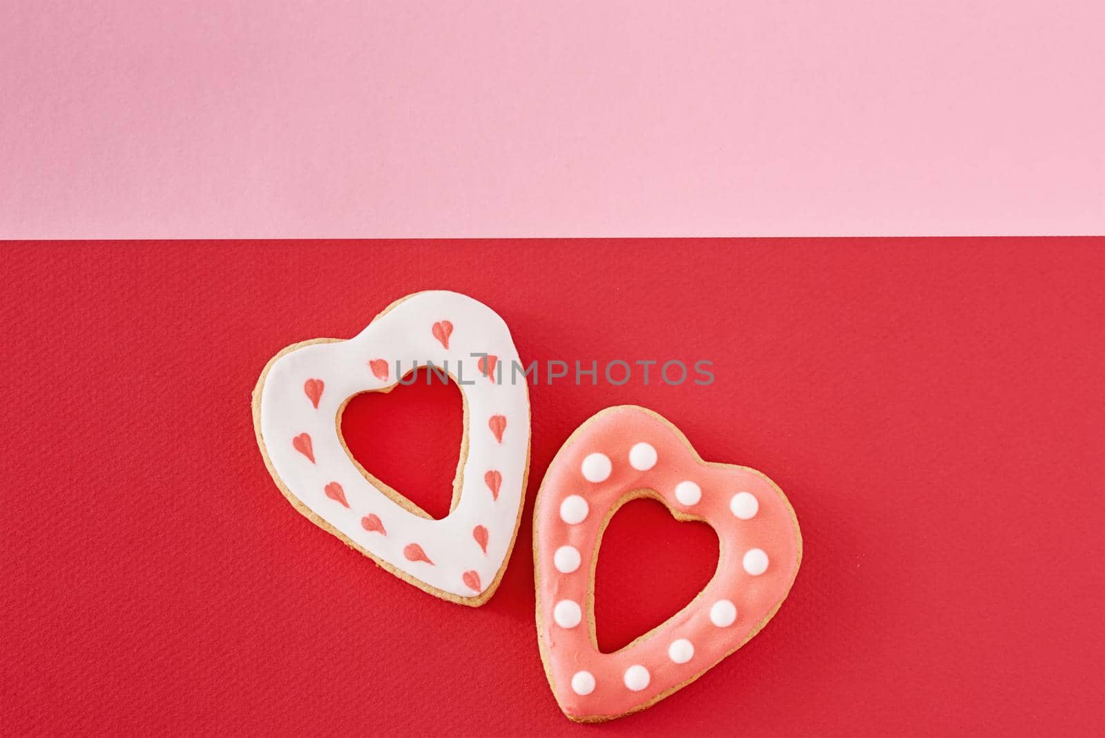 Decorated heart shape cookies on a colored red and pink background, top view by Lazy_Bear