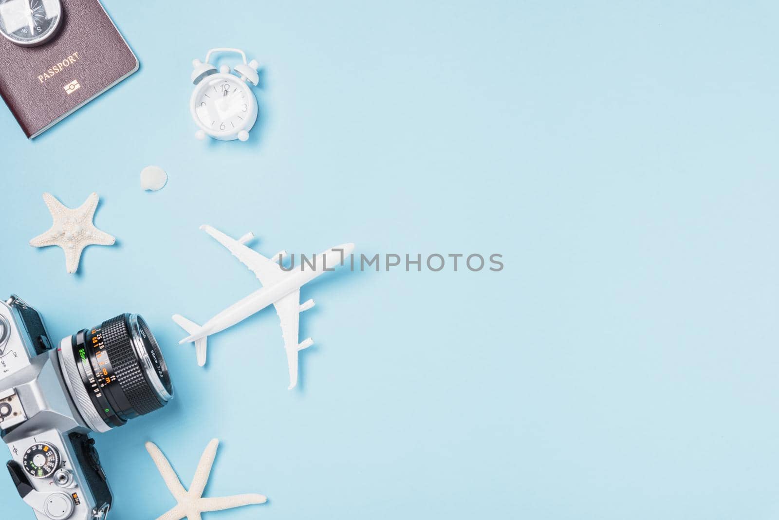 Flat lay top view mockup retro camera films, airplane, passport, starfish, shells traveler tropical accessories on a blue background with copy space, Vacation summer travel and business trip concept