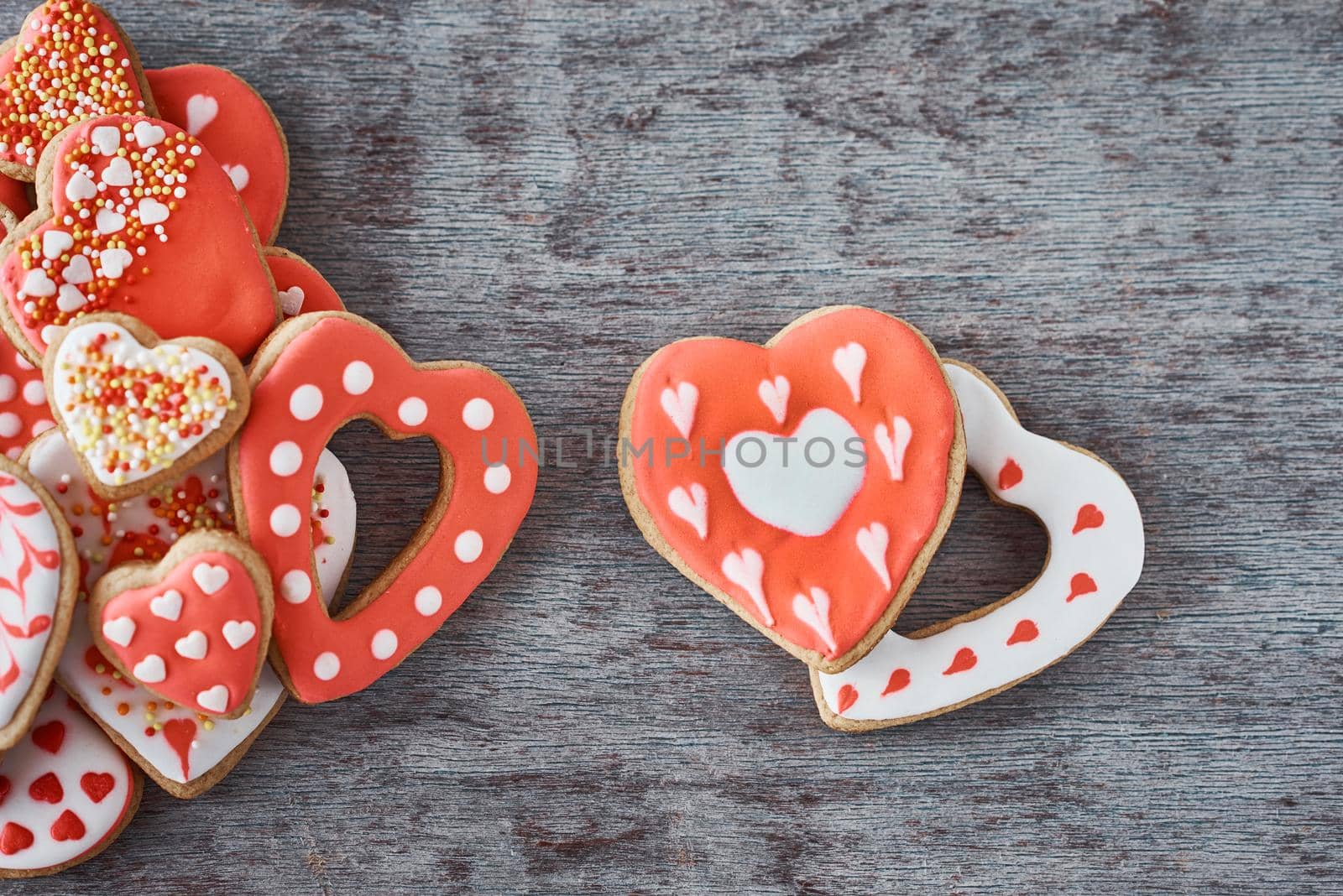 Two heart shape cookiesand many decorated cookies on gray background. Valentines Day concept