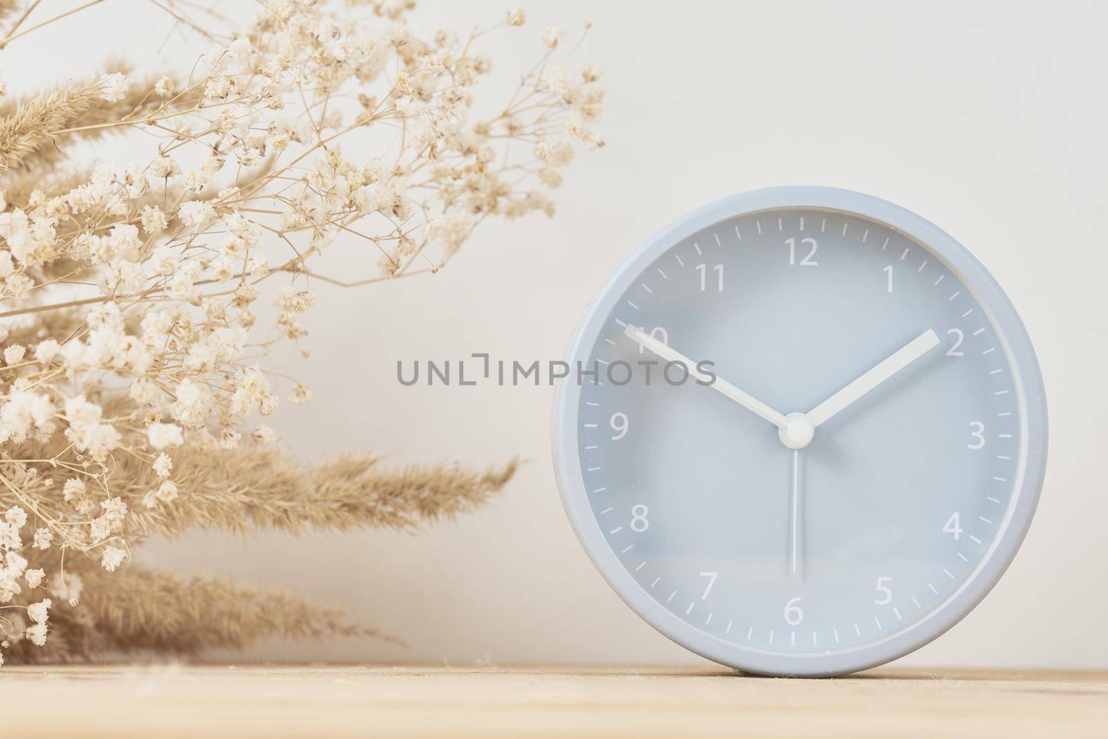 Alarm clock and homemade vase with dries plant on a wooden table by Lazy_Bear