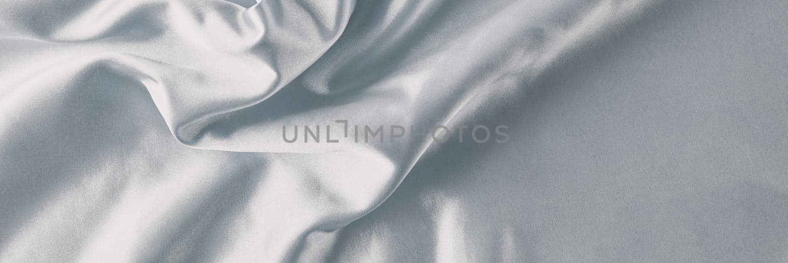 Silver silk background with folds. Abstract texture of rippled satin surface, long banner
