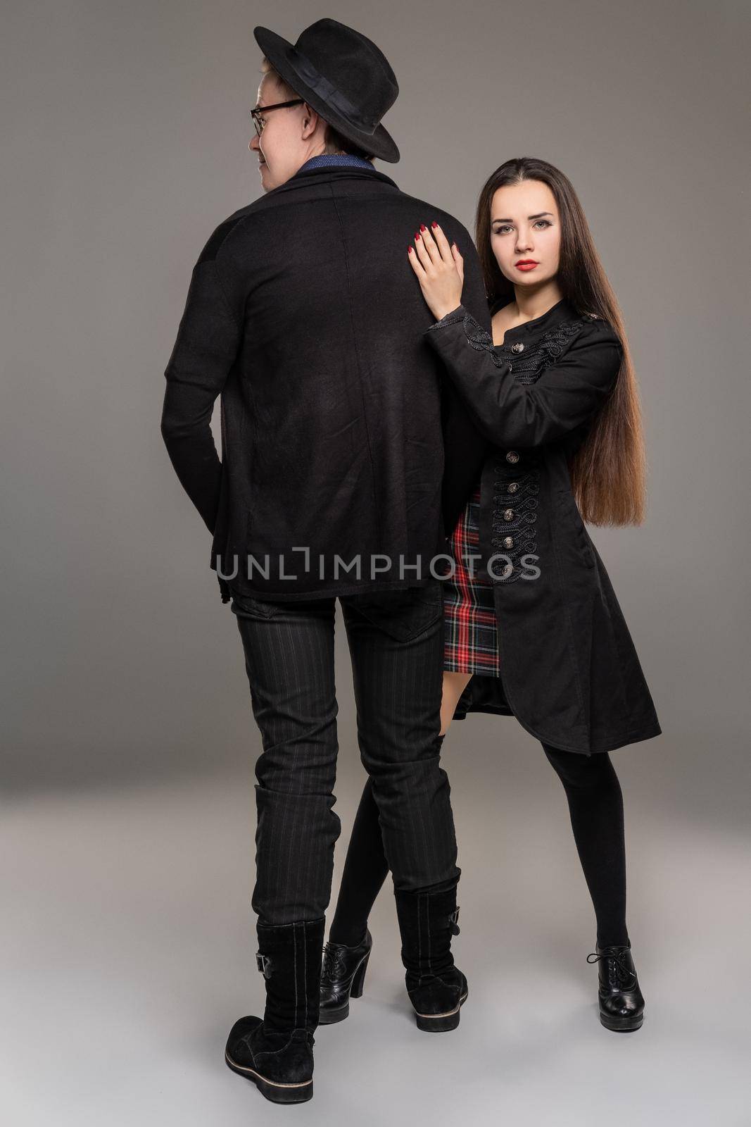 Studio shot of a beautiful young woman and man posing over a gray studio background. by nazarovsergey