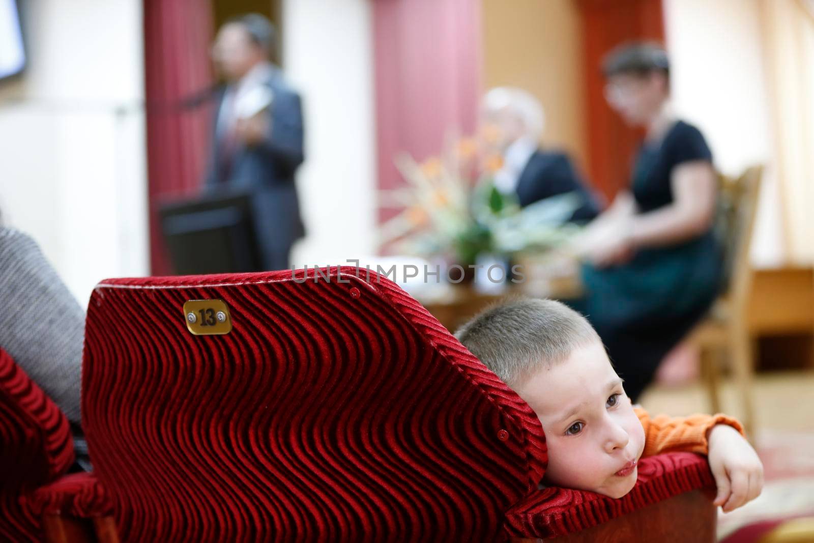 The child is a spectator at a concert which is boring. Uninteresting view