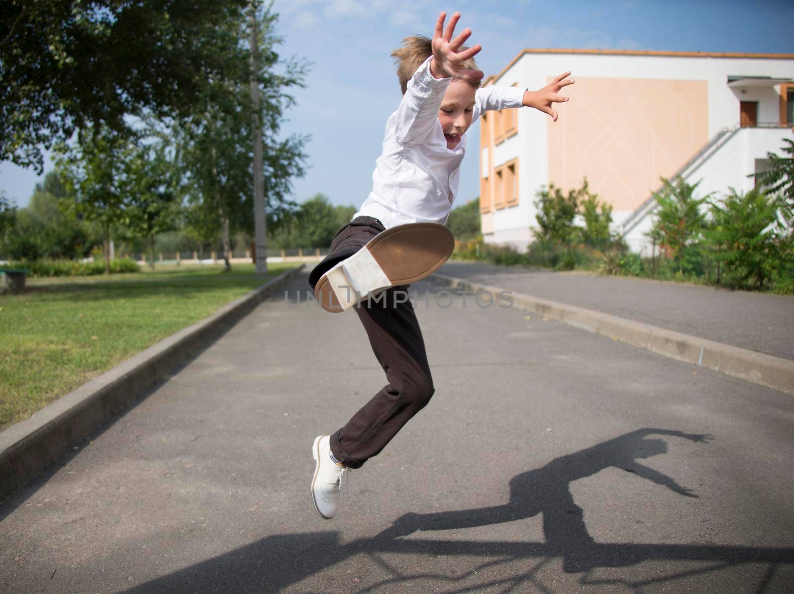 The boy jumps high. A pupil of primary classes on a street change