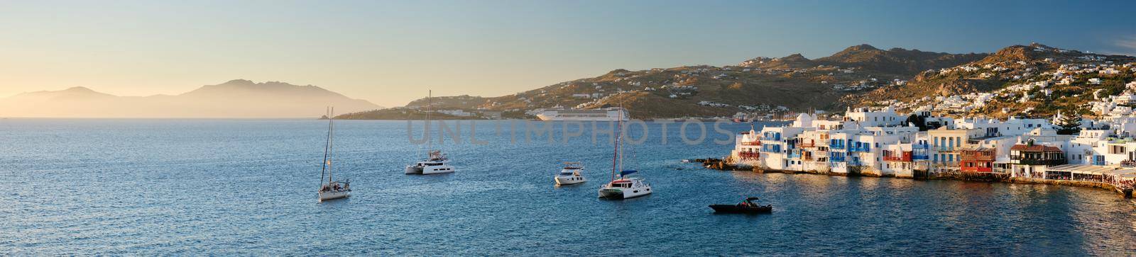Sunset in Mykonos, Greece, with cruise ship and yachts in the harbor by dimol