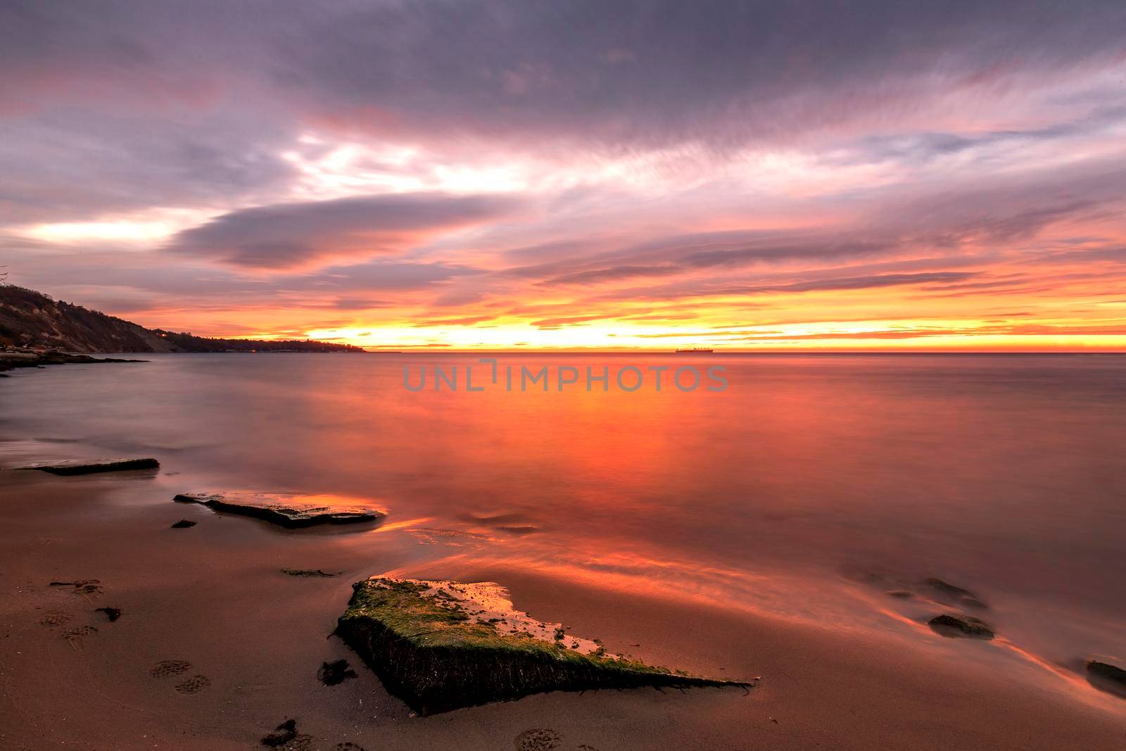 Exciting long exposure red sunrise over the sea.