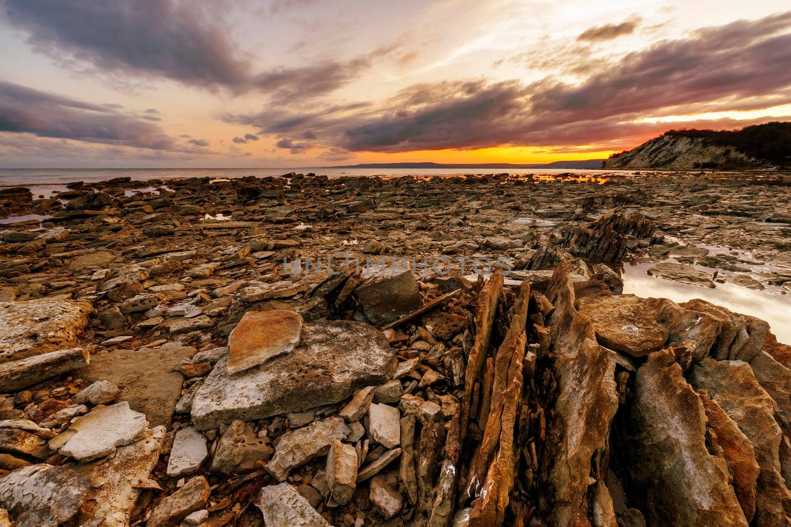 Exciting sunset at sea rocky coast and colorful sky