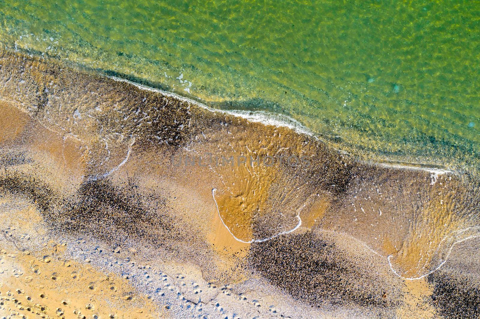 Aerial top view from drone to the coastline. Calm sea and sand