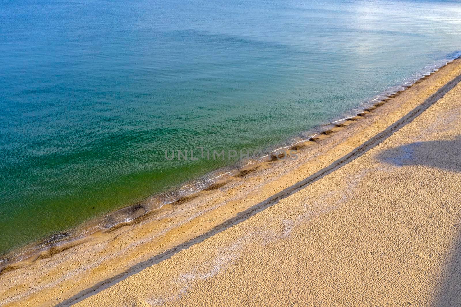 Aerial top view from drone to the coastline. Calm sea and sand by EdVal