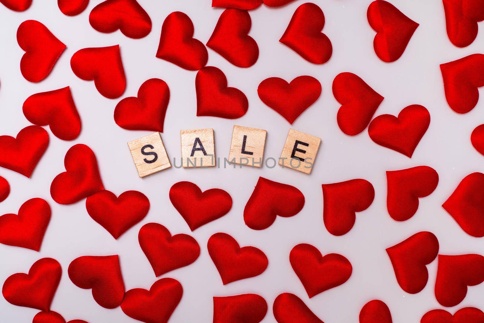 Sale inscription, a lot of red hearts on a white background