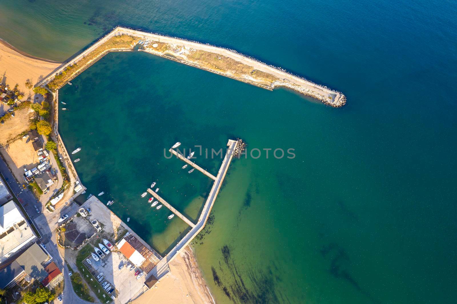 Aerial top view from drone to the seacoast and small marina with boats and yachts.