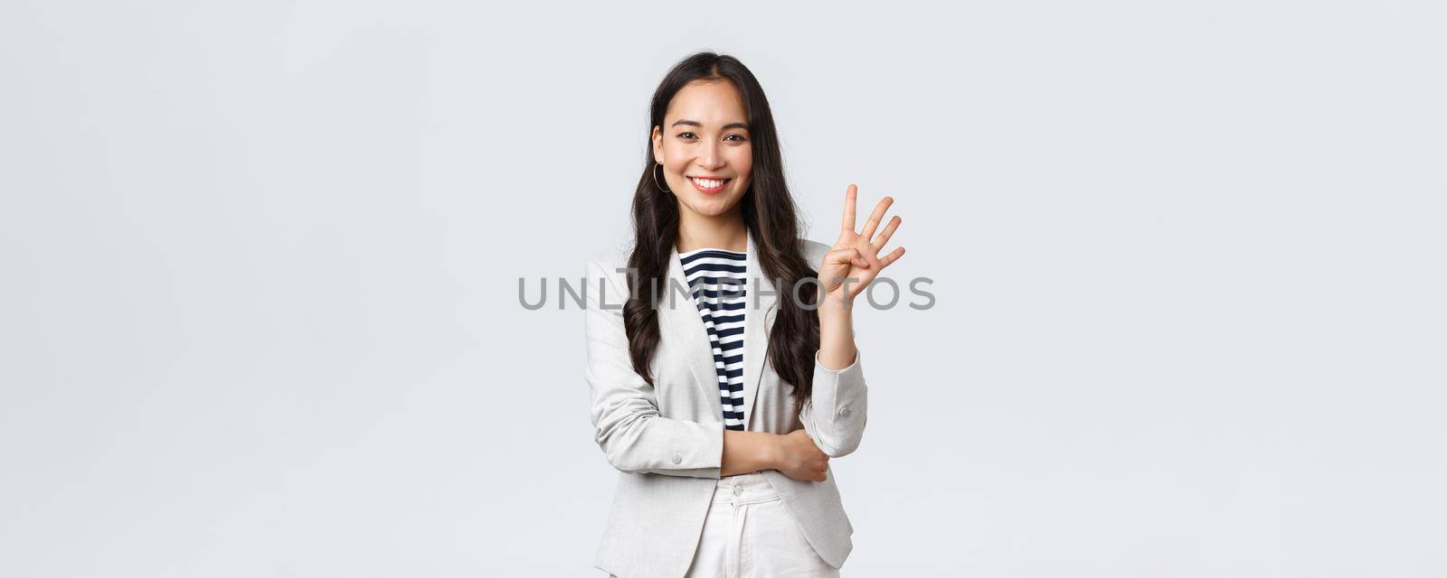 Business, finance and employment, female successful entrepreneurs concept. Successful female businesswoman, asian real estate broker pointing finger, showing number four and smiling.
