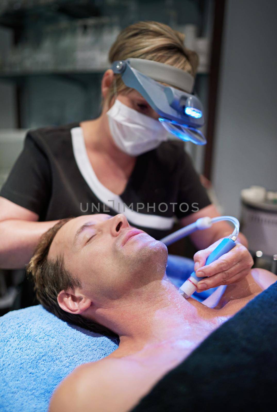Modern technology making beauty pain free. Shot of a man getting a non-invasive face lift at a beauty clinic. by YuriArcurs