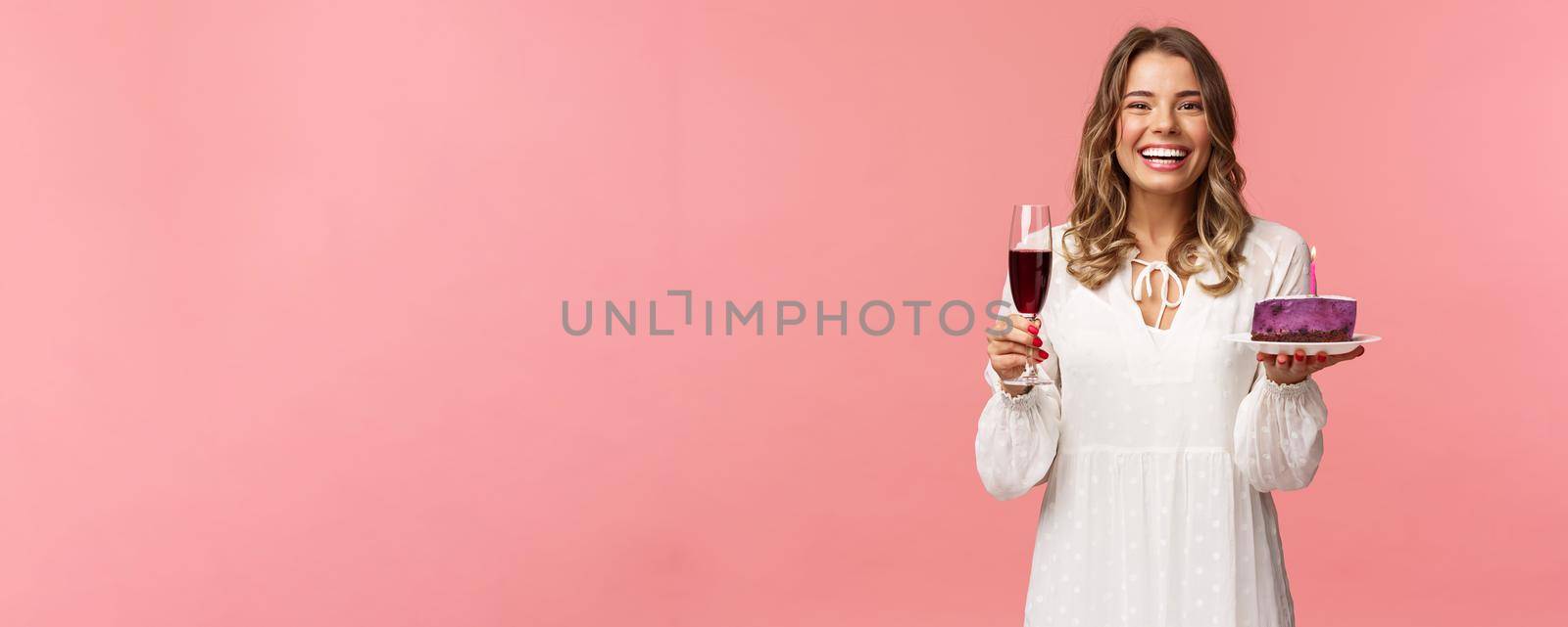 Holidays, spring and party concept. Portrait of excited good-looking young tender girl celebrating birthday, having fun with friends, eating b-day cake and drink wine from glass, laughing joyfully by Benzoix