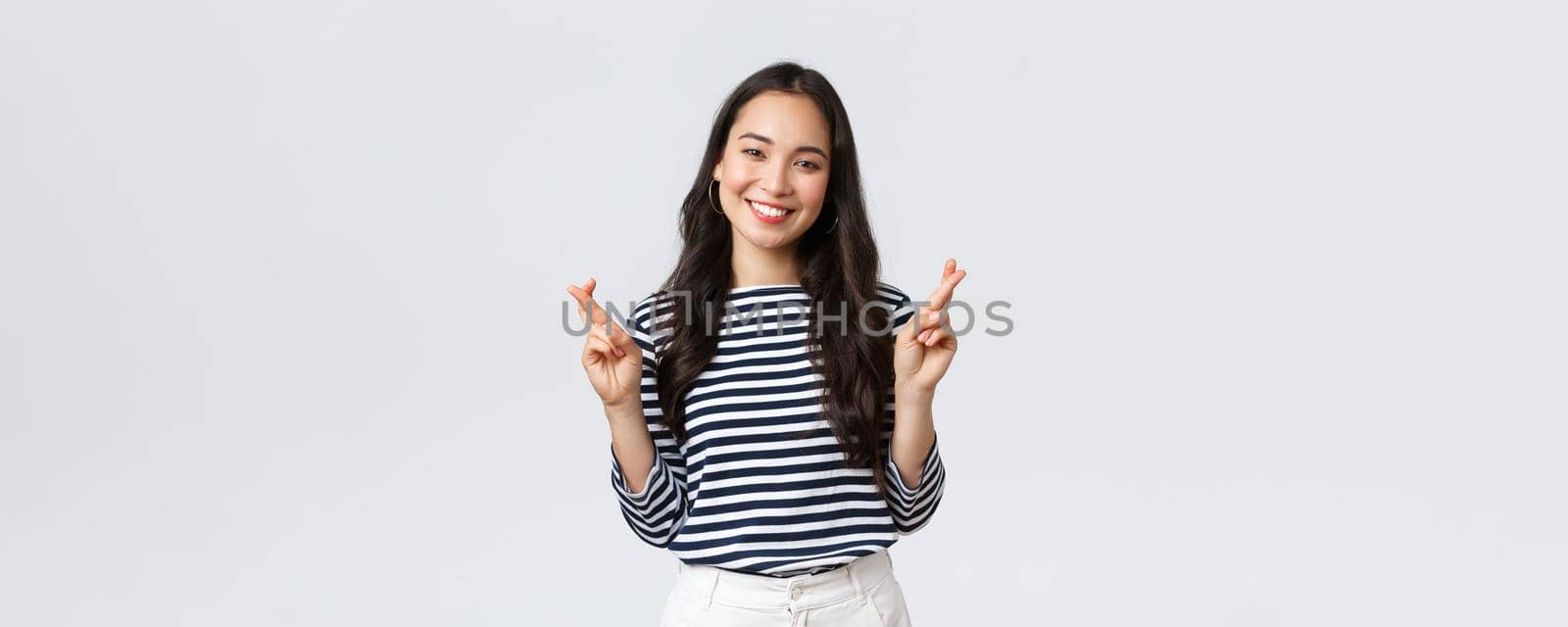 Lifestyle, people emotions and casual concept. Hopeful excited cute korean female making wish with fingers crossed, smiling, anticipating positive news, pleading dream come true by Benzoix
