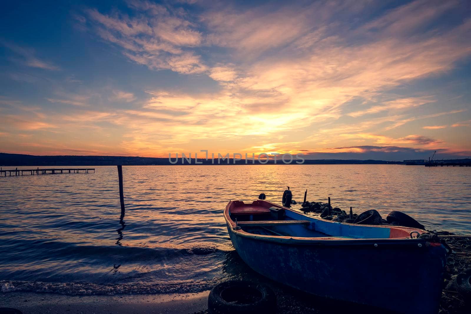 Moored wooden boat after sunset at the shore