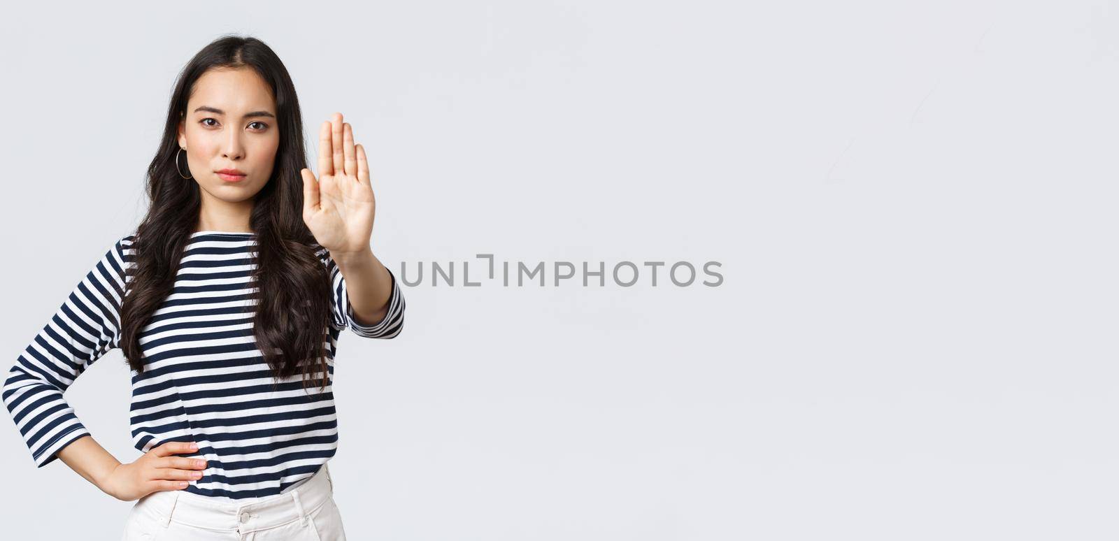 Lifestyle, beauty and fashion, people emotions concept. Serious-looking displeased asian woman tell to stop, extend hand disappointed to prohibit or restrict something bad happening by Benzoix