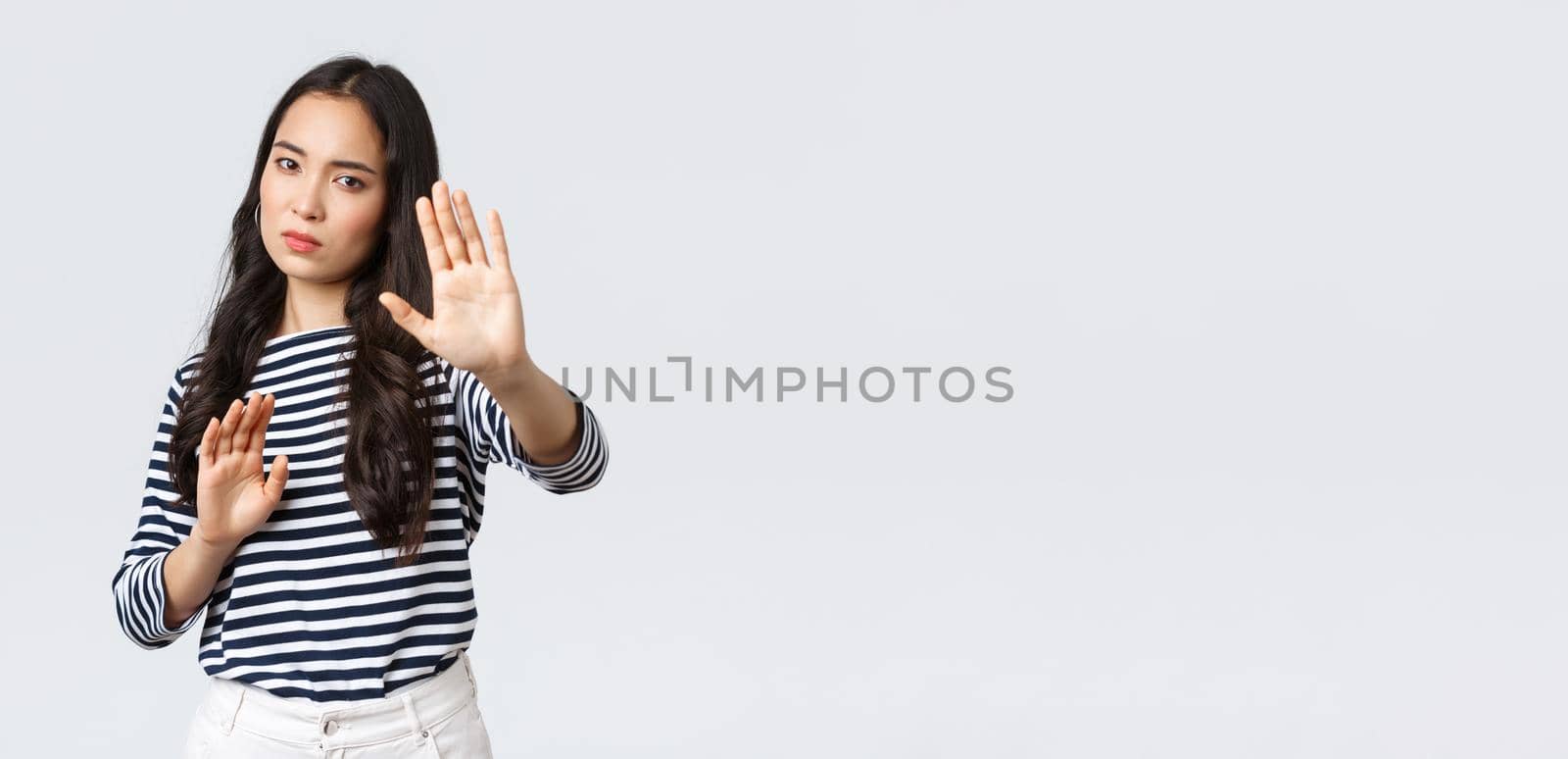 Lifestyle, beauty and fashion, people emotions concept. Annoyed woman feeling uncomfortable being photographed, asking turn-off camera, raising hands up defensive, protecting face from flashlight.