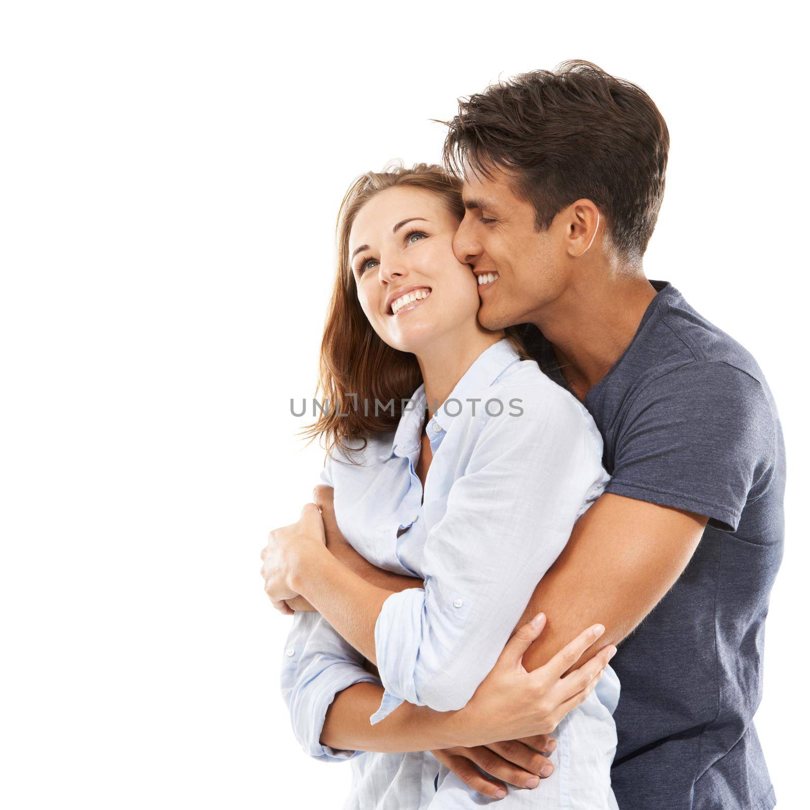 A happy young couple embracing happily against a white background.