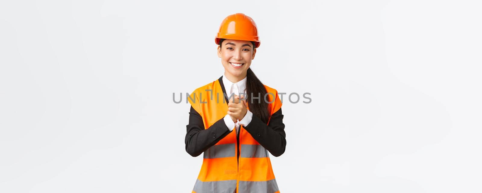 Thankful successful asian female architect greet investors or clients at construction area, wearing safety helmet and jacket, shaking clenched hands in appreciation, being grateful for trust by Benzoix