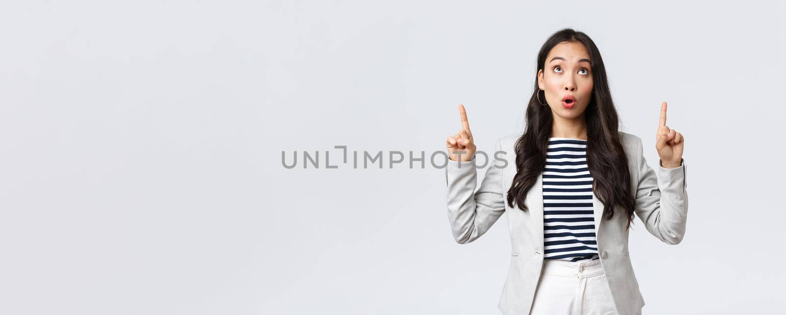 Business, finance and employment, female successful entrepreneurs concept. Real estate worker in white suit inform people about special offer, pointing fingers up saying wow.