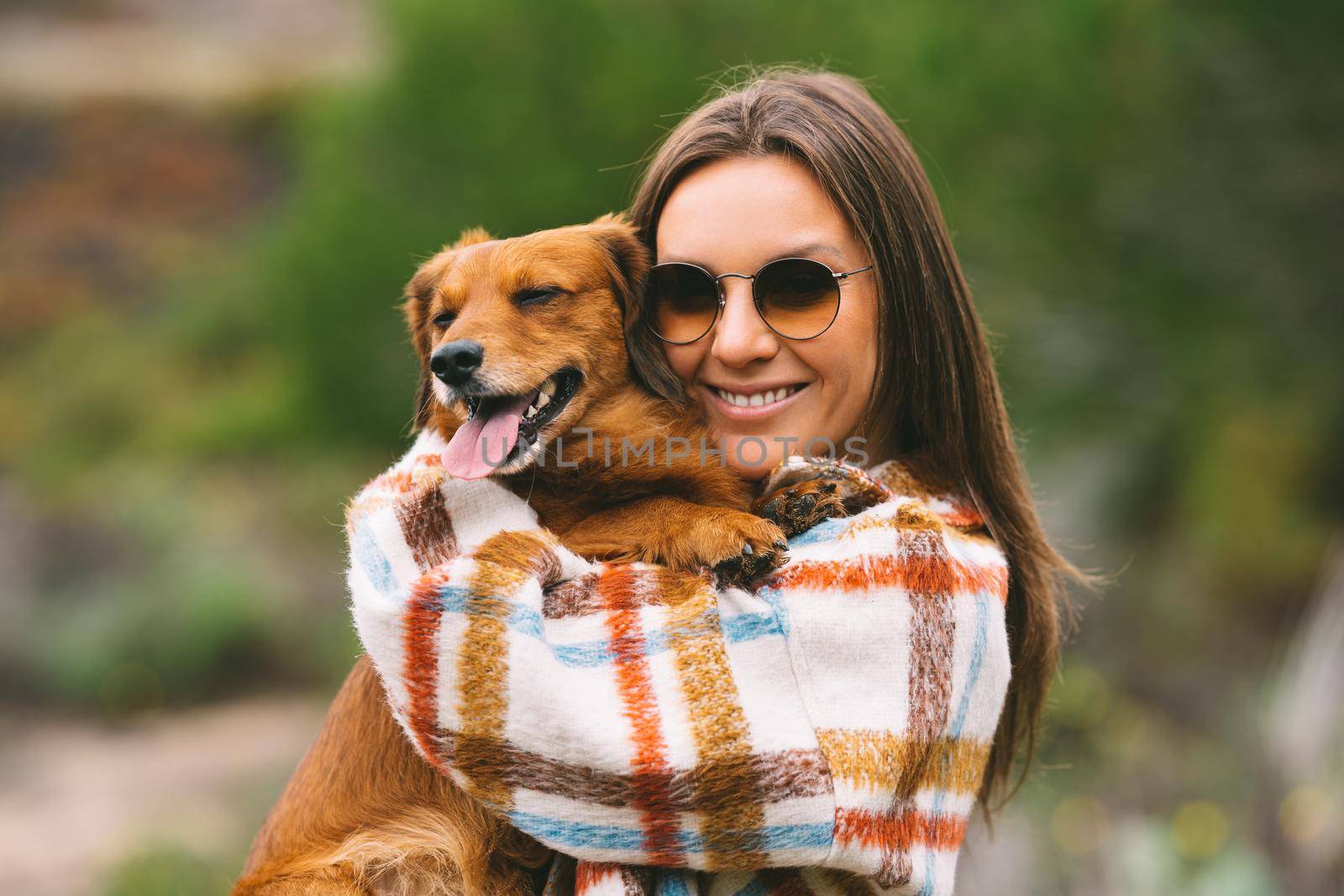 Woman hugging and holding dachshund dog in arms. Dog and owner together, best friends by DariaKulkova