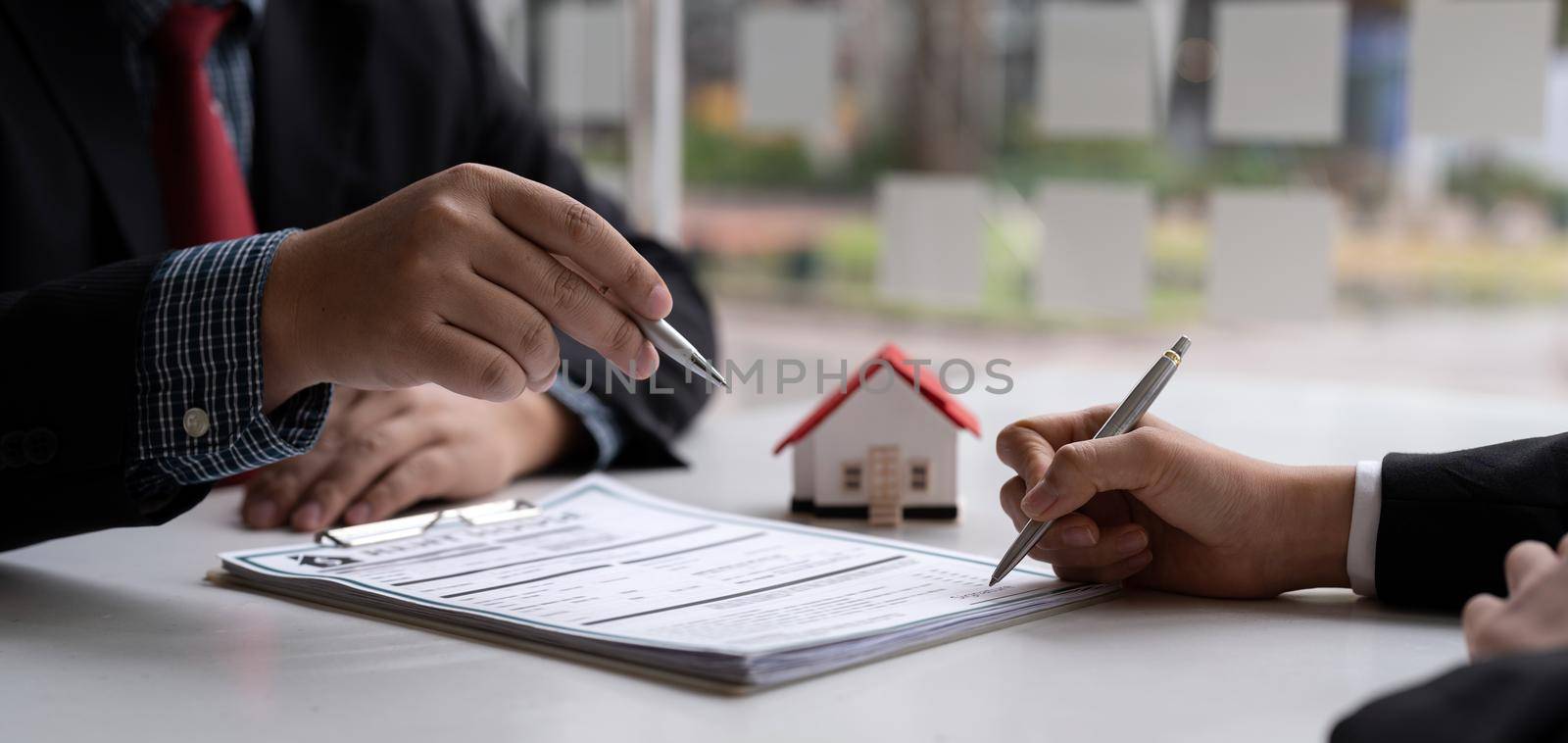 Real estate agent and customer signing contract to buy house, insurance or loan real estate.rent a house,get insurance or loan real estate or property.