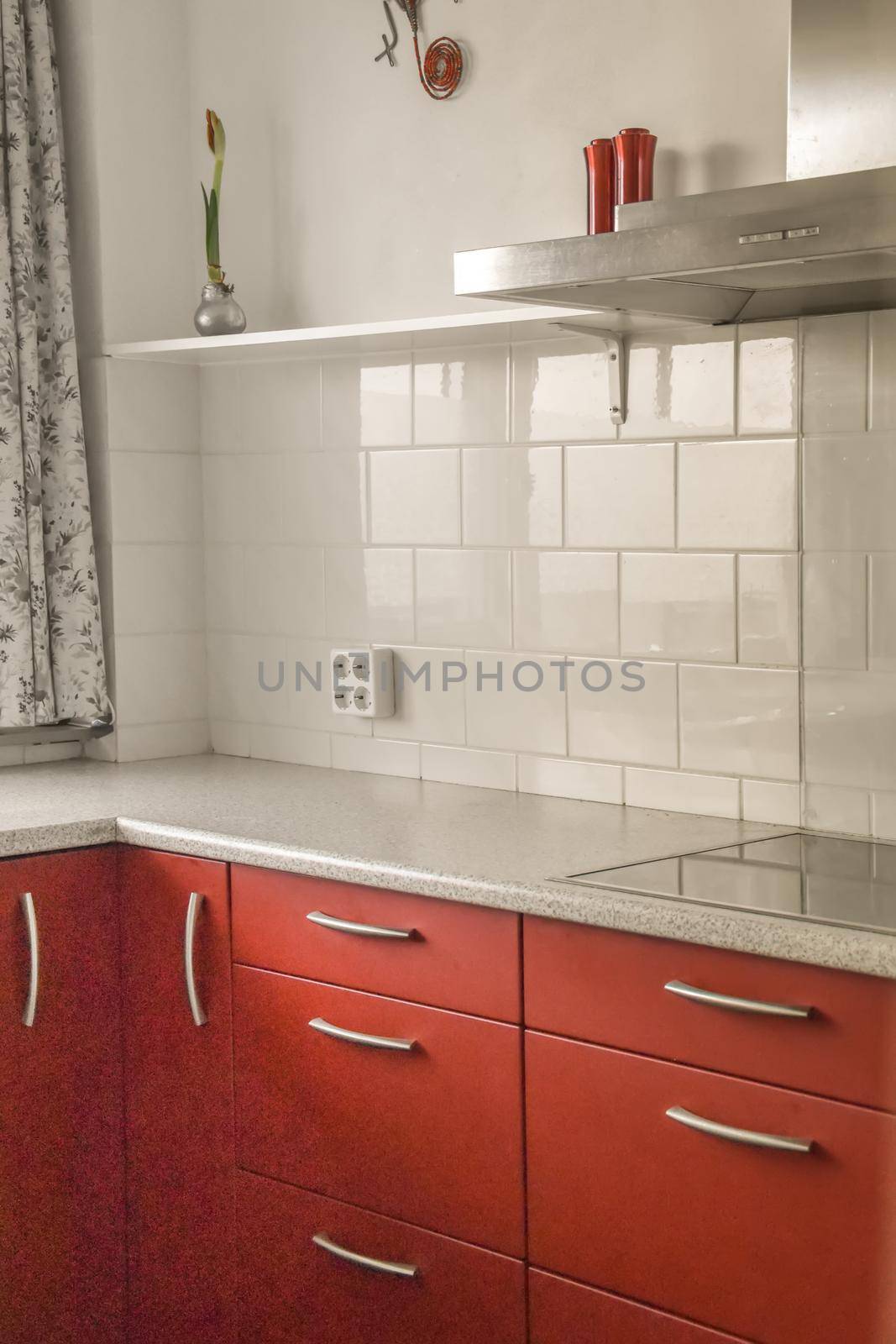 Small kitchen with red furniture and tiled floor in a modern house