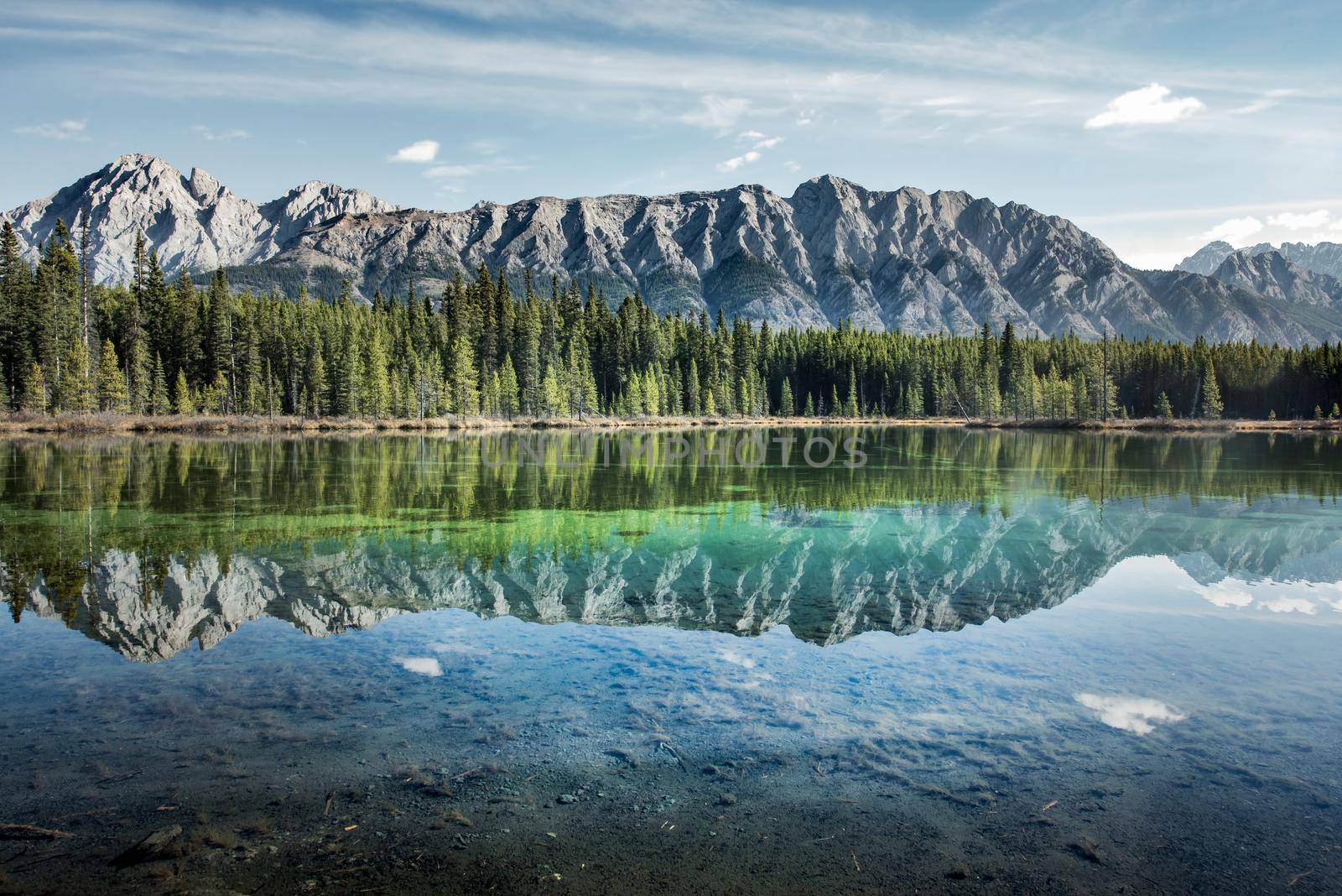 Sky and peaks refelcted in crystal clear lake in Calgary by lisaldw